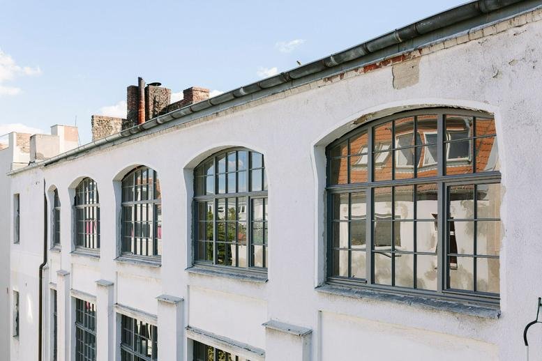 Exterior view of the white industrial facade of Business Park, Glogauer Straße 2, Kreuzberg, Berlin.