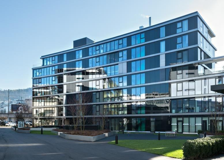 Exterior view of the modern glass-facade building at Gotthardstrasse 26.