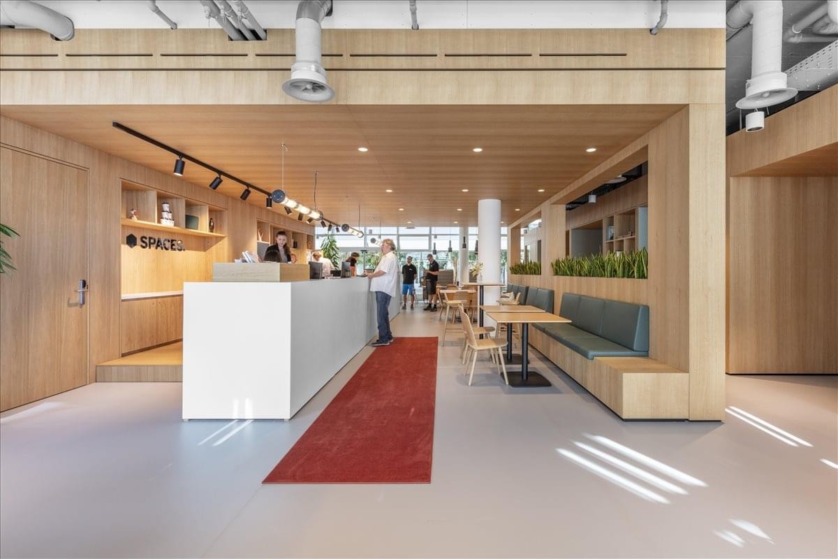 Spacious reception and communal lounge at Grafenauweg 8, Zug, Switzerland with wood paneling and red runner rug.