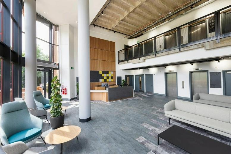 Spacious reception lobby at Unit 7, Greenways Business Park with high ceilings, modern seating, and desk.