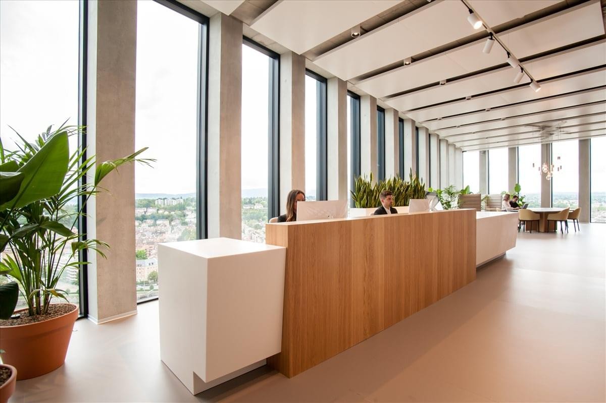 Bright, expansive reception lobby of the Grosspeter Tower with warm wood paneling and large windows.