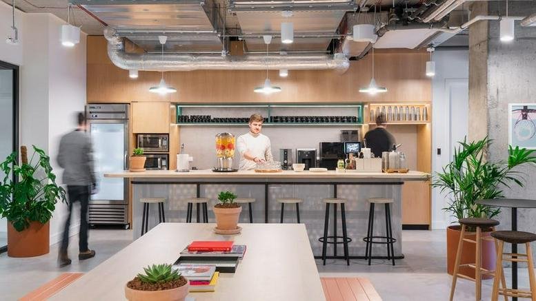 Spacious communal kitchen and cafe area at Grzybowska 62, Warsaw, Poland with staff and breakfast bar.