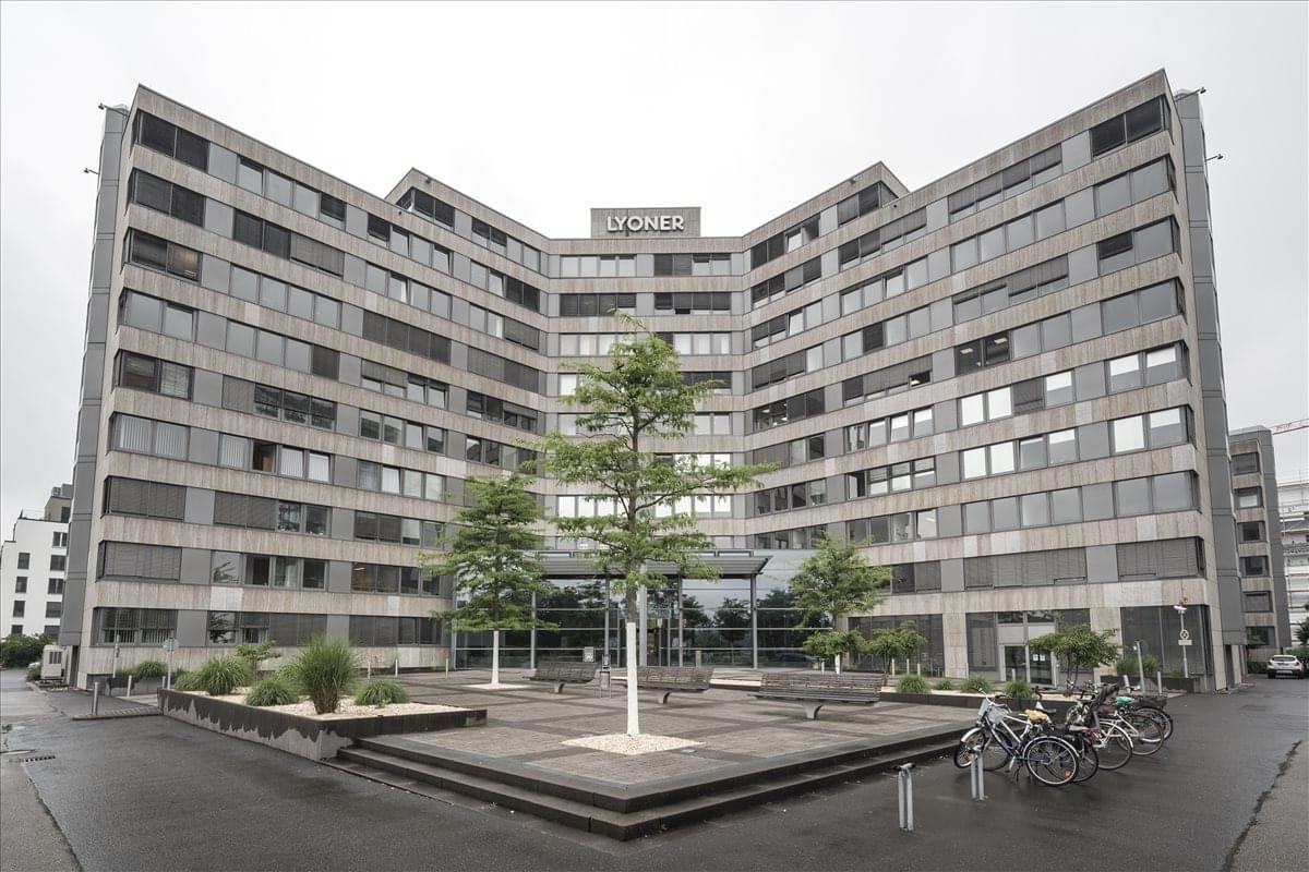 Symmetrical exterior view of the modern office building at Hahnstraße 70 with glass facade and central courtyard.