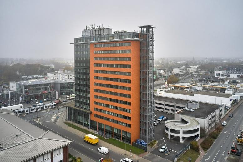 Exterior view of Hanauer Landstraße 328-330, a modern orange and grey high-rise building.