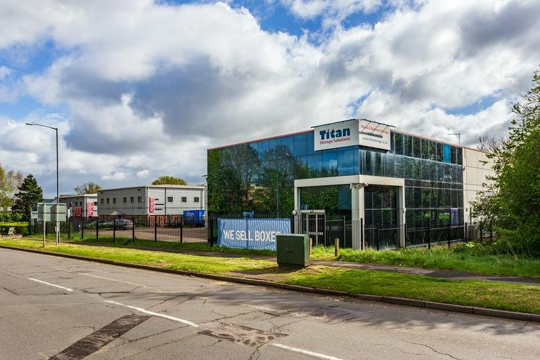 Exterior view of the modern glass-fronted Titan building with manicured lawn.