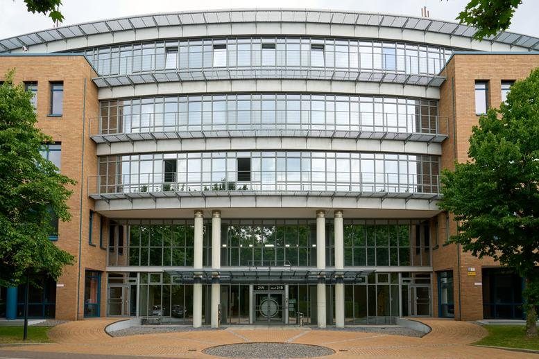 Exterior view of the curved glass and brick building at Heltorfer Straße 2-6 & 12-22.