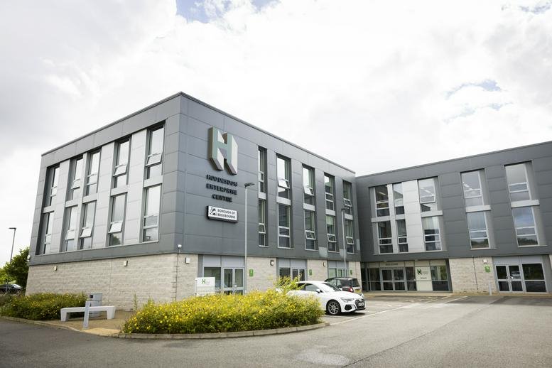 Exterior view of the modern grey and stone facade of Hoddesdon Enterprise Centre with a large N logo.