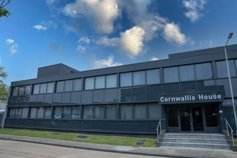 Exterior view of the modern black-cladded Cornwallis House under a blue sky.