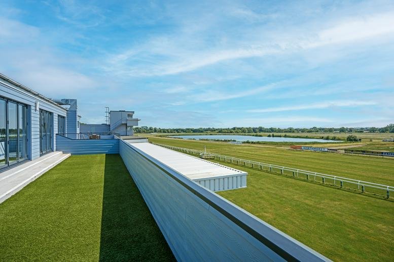 Exterior view of the grandstand building at Huntingdon Racecourse overlooking the green track.
