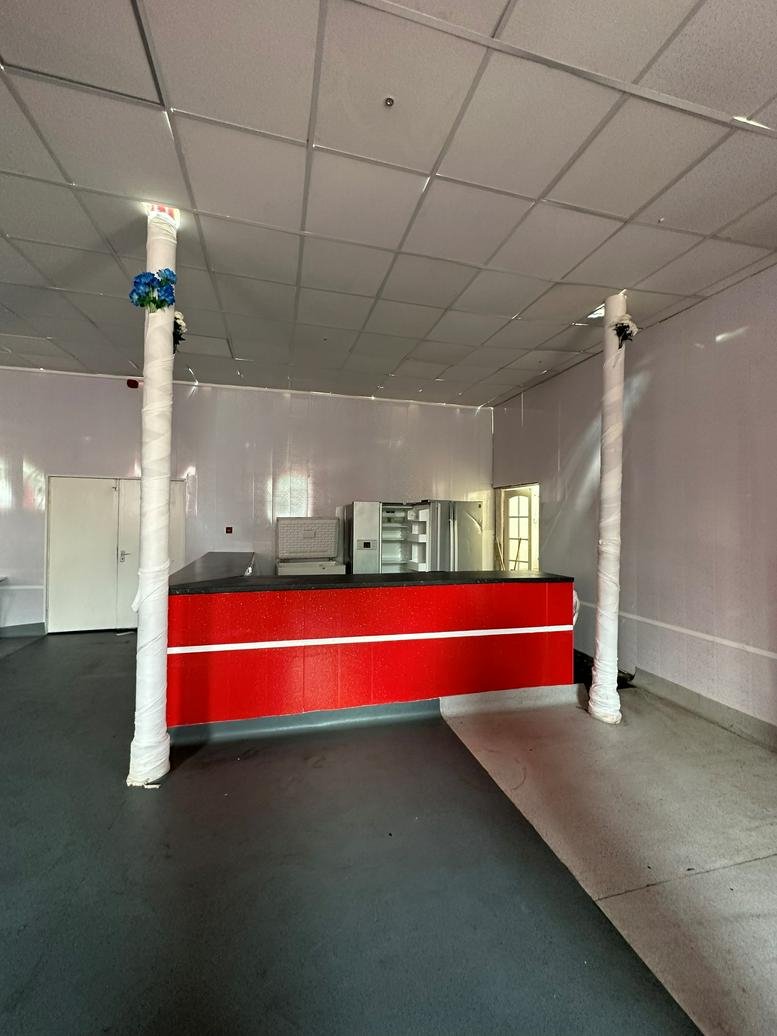Interior view of the red reception counter at Ivy Business Centre, Silicon City.