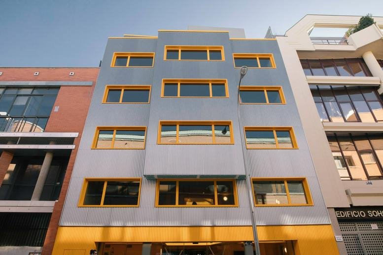 Exterior view of the blue and yellow facade at Javier Ferrero 10, Prosperidad, Madrid.