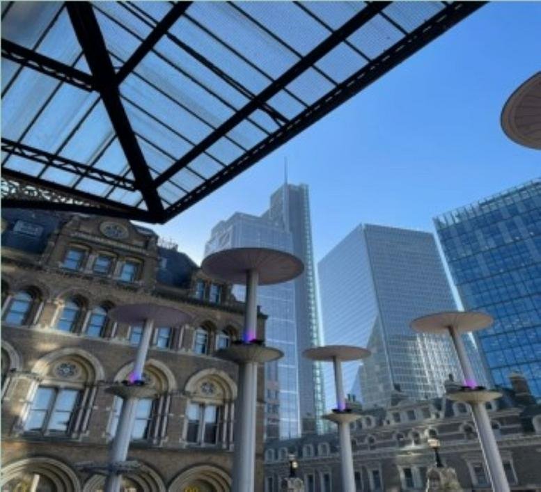 Rooftop terrace featuring modern heat lamps and views of nearby city skyscrapers.