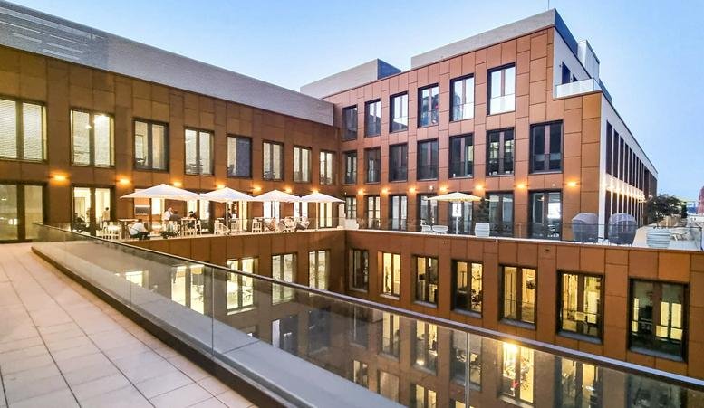 Building courtyard showing multiple levels with outdoor terrace seating.