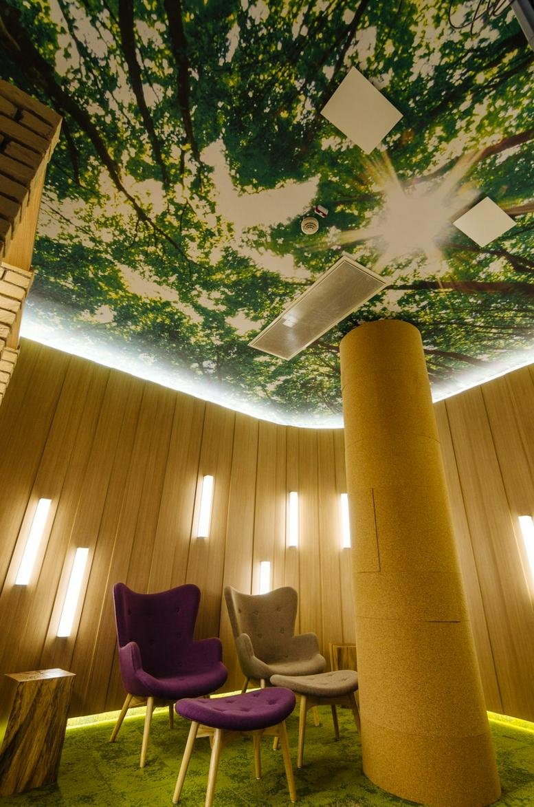 Cozy quiet room with purple armchairs and a forest-themed ceiling.
