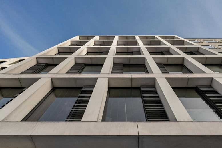 Exterior view of the modern stone and glass facade at Karlsplatz 3, Munich, Bavaria.
