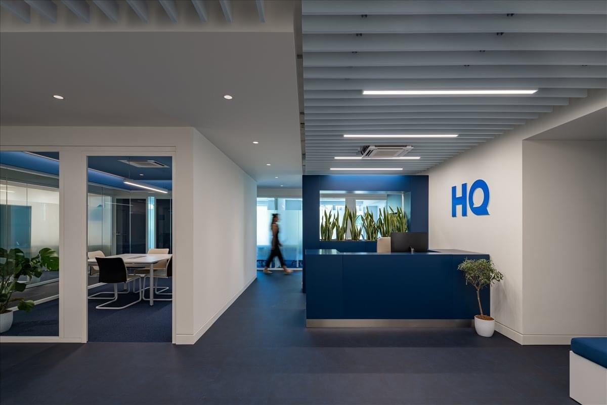 Modern reception area at Kefallinias 46, Kipseli, Athens featuring a navy desk and blue HQ logo.