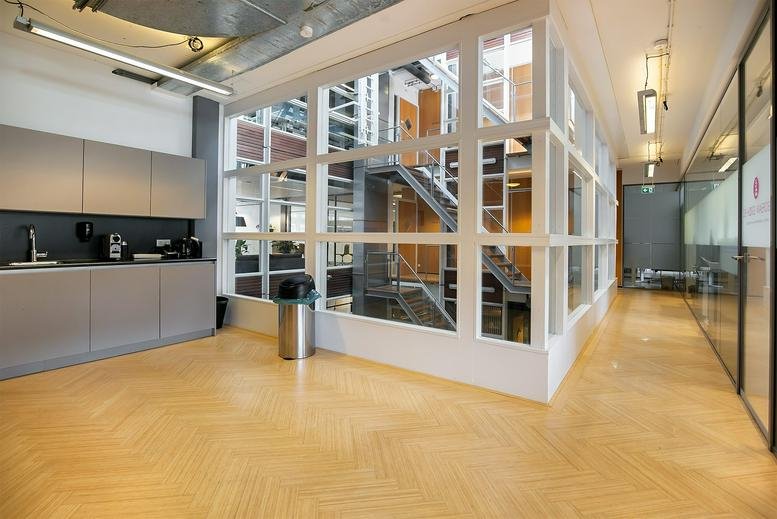 Modern office kitchenette at Kennemerplein 6, 14, Haarlem with a sleek grey counter and coffee machine.