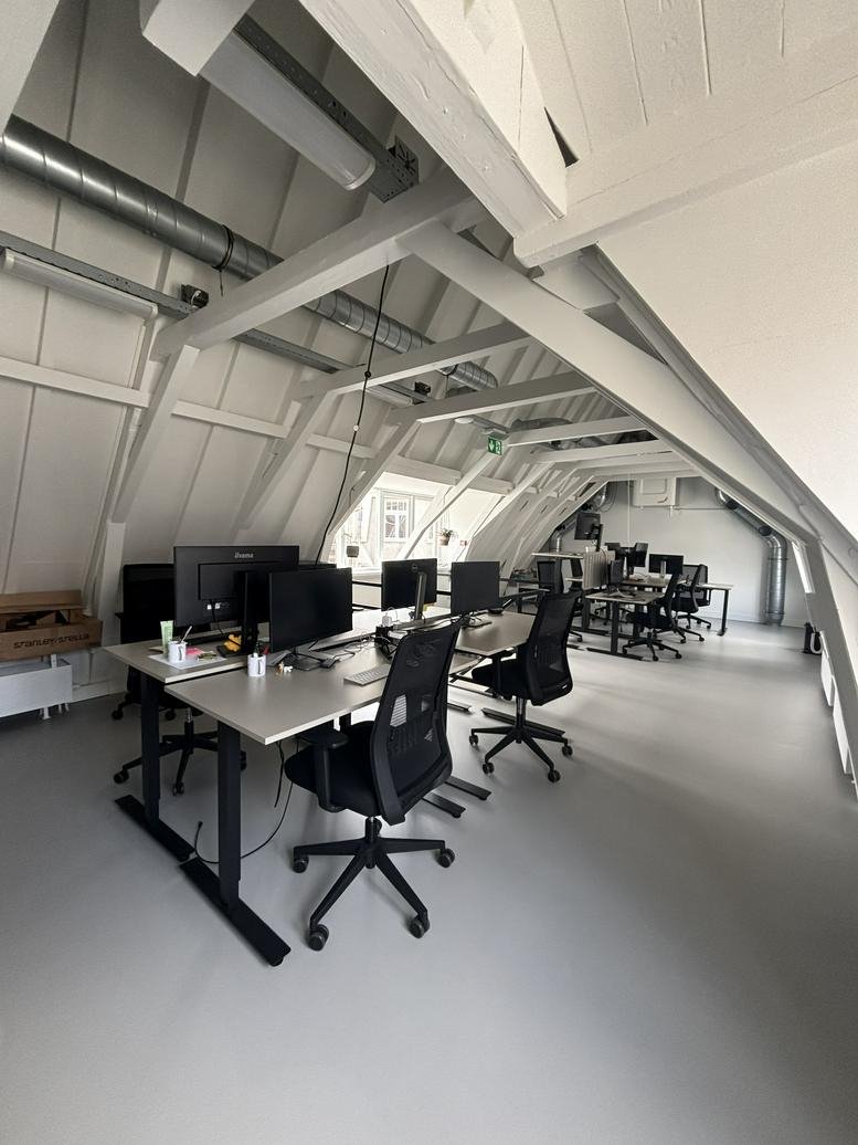 Attic office at Kloveniersburgwal 131H with white timber beams and multiple workstations.