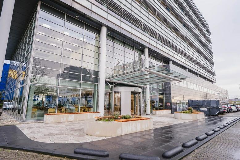 Exterior view of the glass-facade building at Laarderhoogtweg 7, Amsterdam.