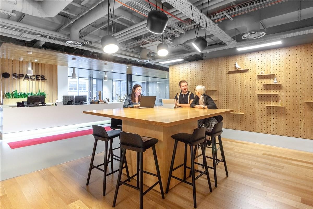 The reception area of the Lewis Building featuring a wooden feature wall and a communal high table.