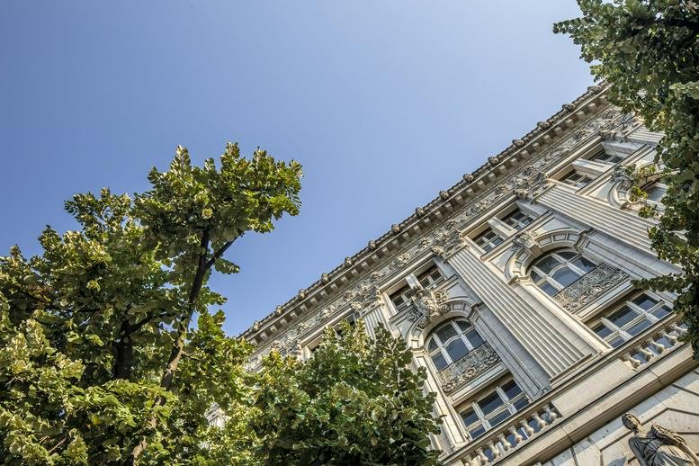 Exterior facade of the ornate, historic Linden Palais building featuring arched windows and greenery.