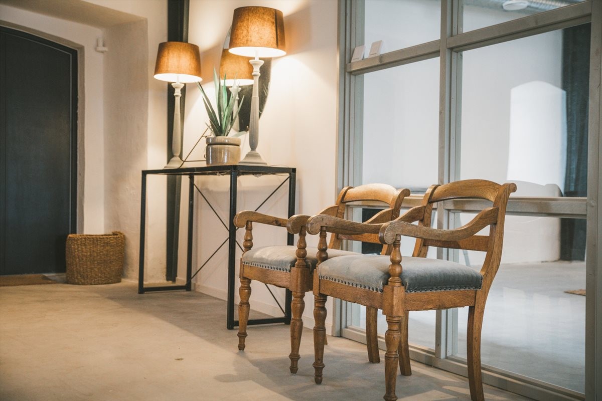 Reception area at Loarp Gardskontoret with vintage chairs, console table, and warm lamp lighting.