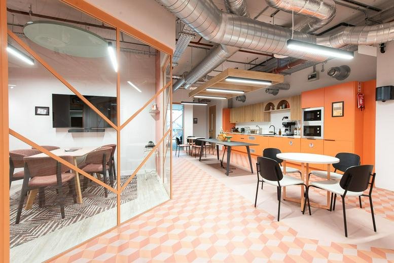 Spacious communal kitchen and dining area with orange cabinetry and modern light fixtures at Longley Place.