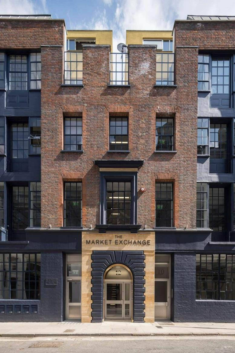 Symmetrical red brick facade and arched stone entrance of The Market Exchange on Macklin Street.