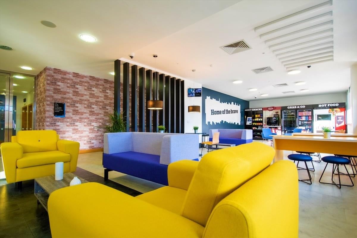 Vibrant reception and breakout lounge with yellow armchairs at 575-599 Maxted Road.
