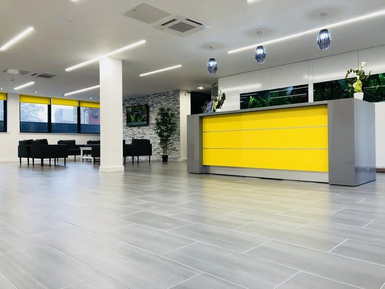Spacious reception area with a bright yellow front desk at Miller House, 47-49 Market Street, Farnworth.