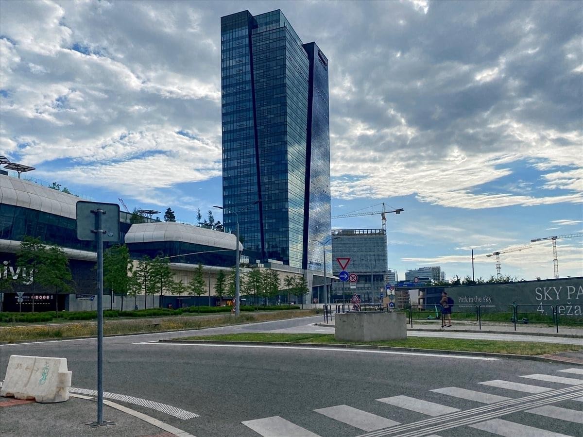 Exterior view of the modern glass-facade Nivy Tower against a cloudy sky.