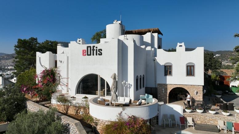Exterior view of the white Mediterranean-style building of Yüksel Çağlar İş Merkezi with arched windows.