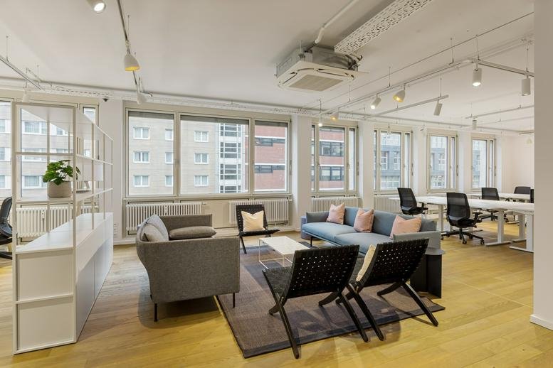 Spacious lounge at Nürnberger Straße, Berlin, Brandenburg with grey sofas and modern black chairs.