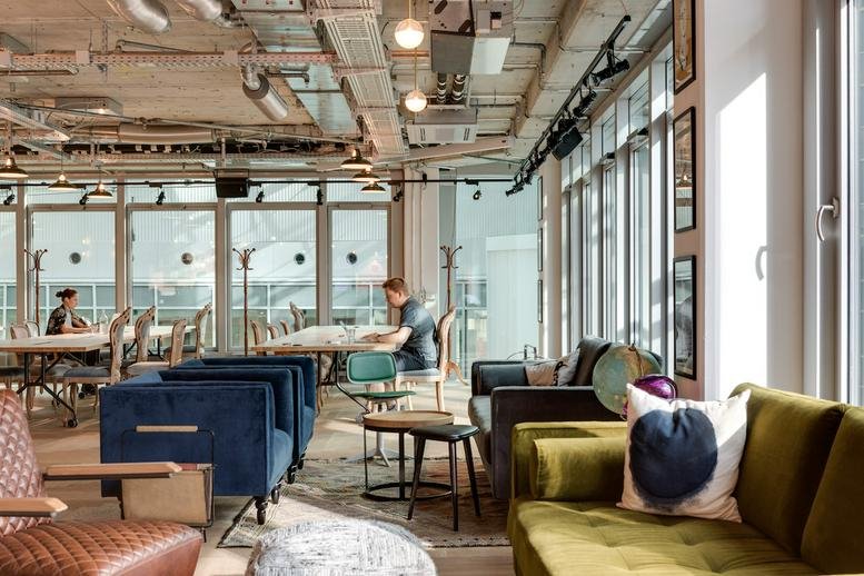 Professional communal workspace at Neue Mainzer Strasse 66, Frankfurt, Hesse featuring a velvet sofa and city views.