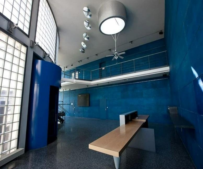 Spacious reception area with high ceilings, blue feature walls, and a large circular skylight at Neue Straße 95.