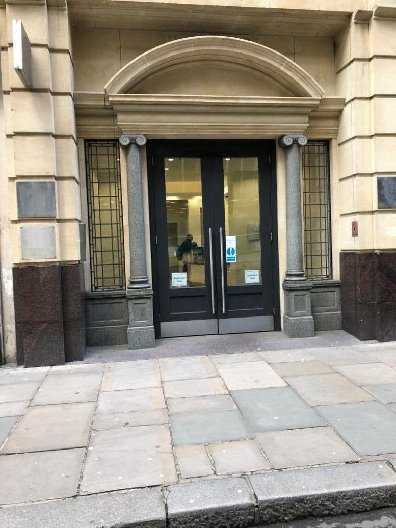 Ground floor entrance to New Liverpool House, 15 Eldon Street with decorative stone pillars and glass doors.