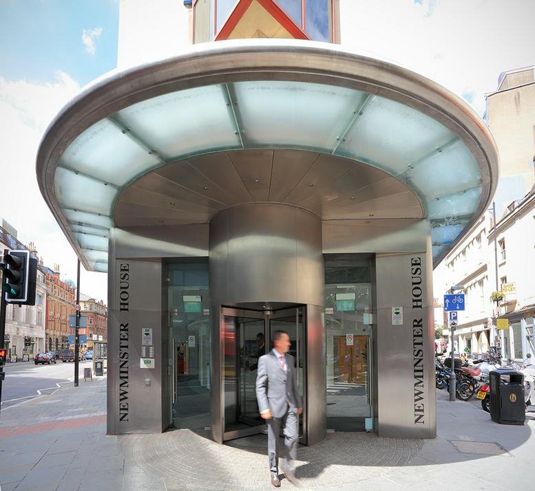 The modern circular glass and steel entrance of Newminster House, 27-29 Baldwin Street.