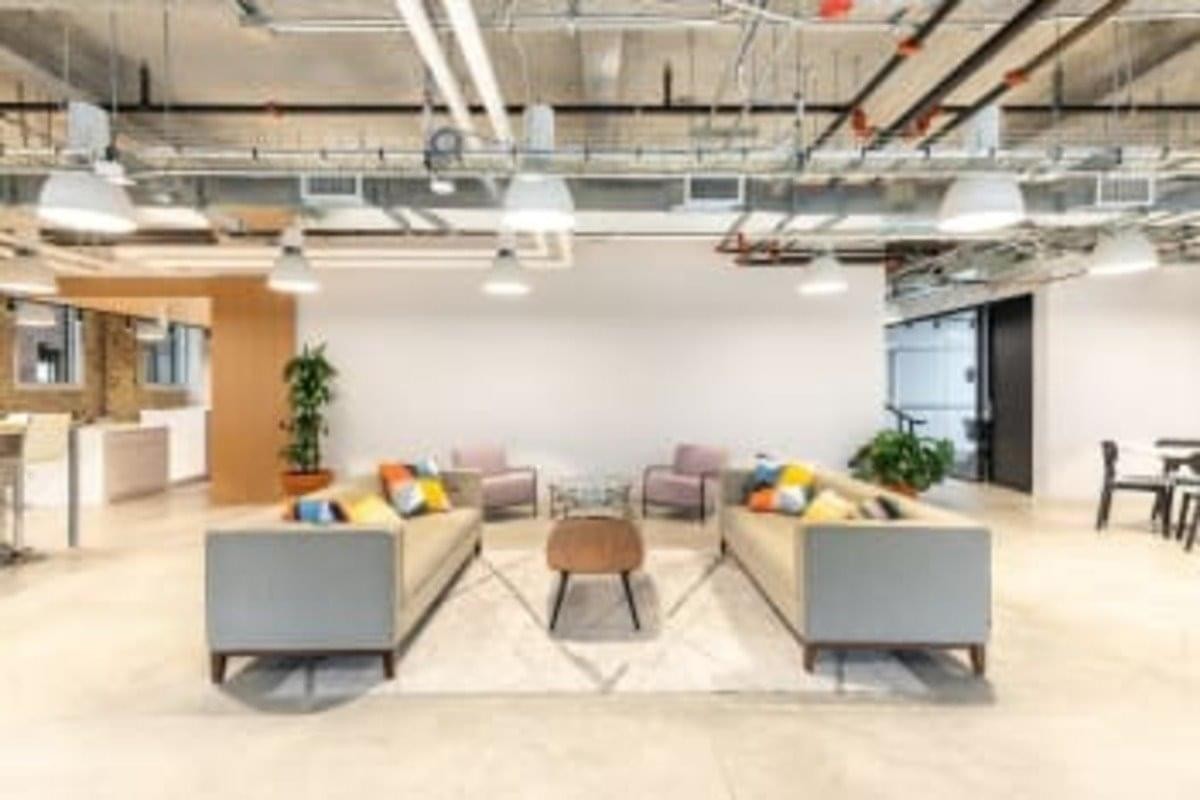 Spacious communal lounge at the News Building featuring comfortable sofas and industrial-style exposed ceilings.