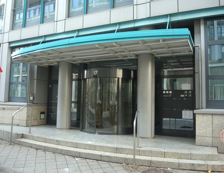 Building entrance of Nordstraße 17-21 with revolving door and teal metal awning.