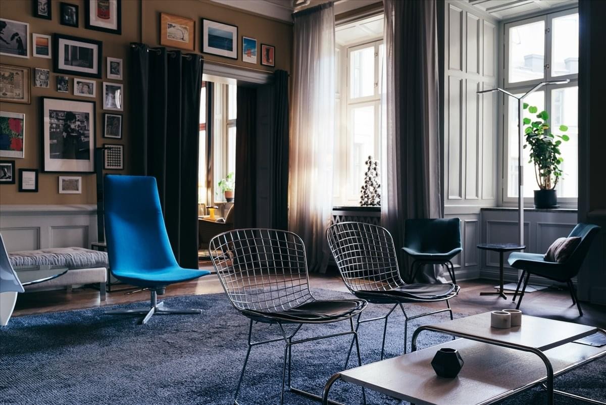 Spacious lounge at Nybrokajen 7, Våning 3, 6, och 8 with blue velvet chair and gallery wall.