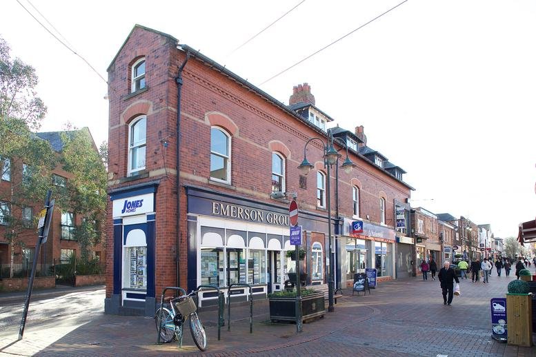 Exterior view of the red brick 1-3 Grove Street, Wilmslow, Cheshire building on a pedestrian street.