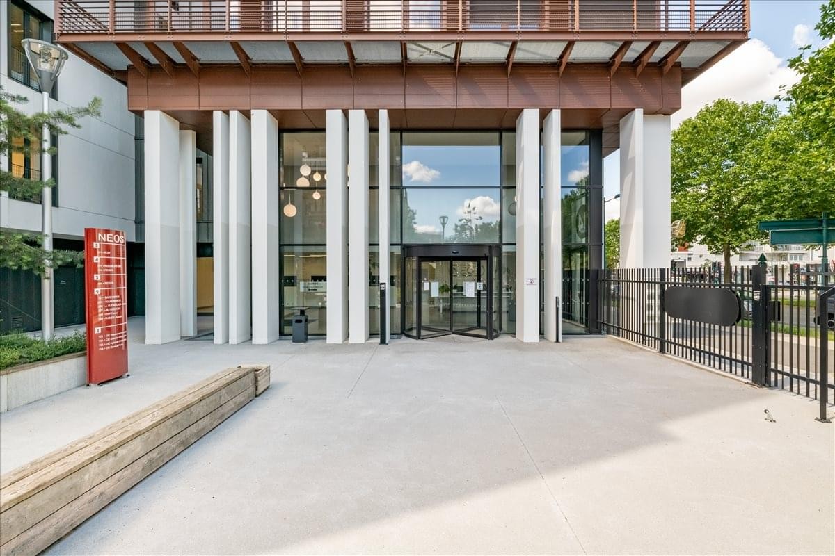 Exterior entrance at 1 Avenue de l’Europe, Montevrain, with white pillars and a wood-paneled overhang.
