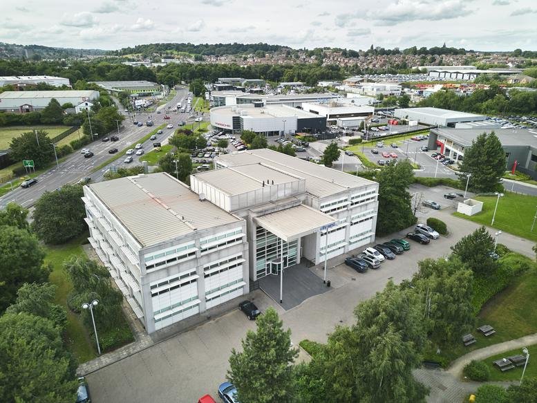 Aerial view of the white three-story 1 City West building on Gelderd Road.