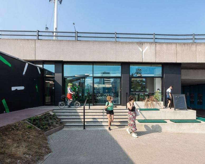 The modern glass and concrete facade of 1 Dock Road under a clear blue sky.