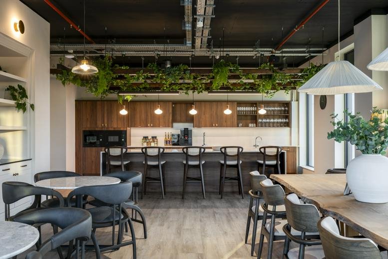 Stylish kitchen and breakout area at 1 Eleanor Ormerod House with greenery and bar seating.