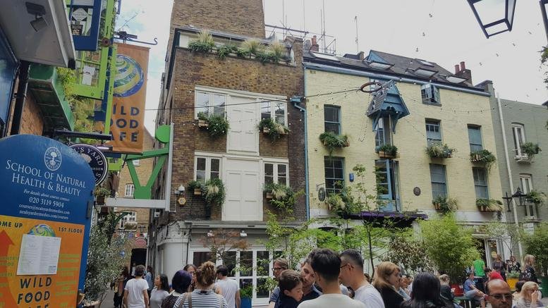 Exterior view of the colorful brick buildings at 1 Neal’s Yard in Central London.