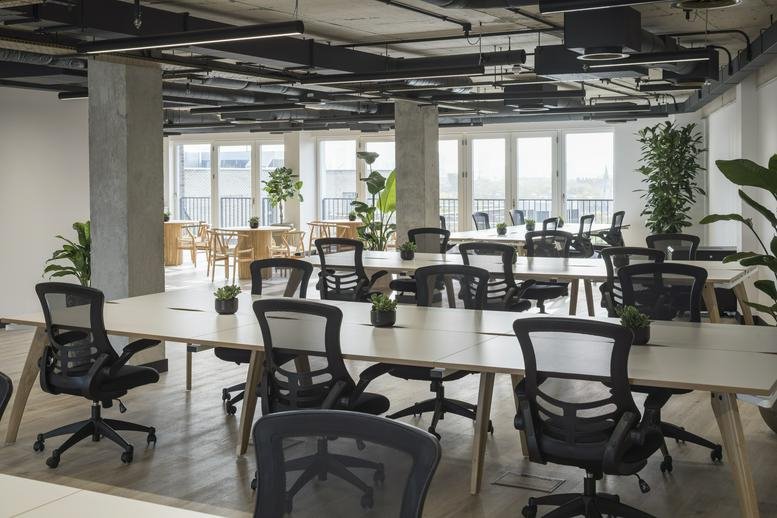 Bright, open-plan workspace at Grid Seven, 1 Sterling Way featuring rows of desks and black ergonomic chairs.