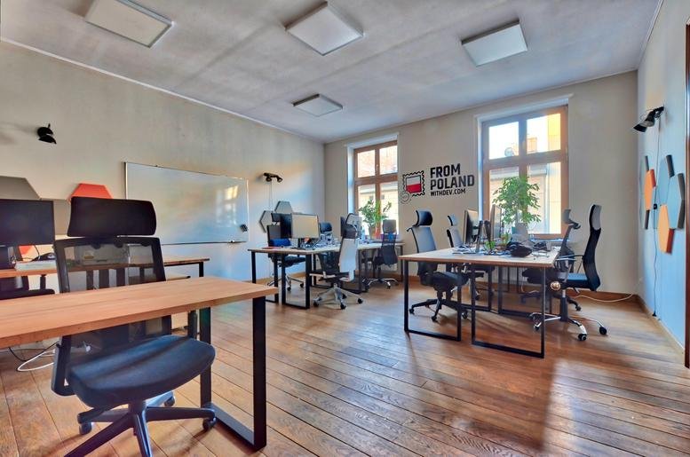 Spacious open-plan workspace at Czysta Cowork, Suite 5 with wooden floors and abundant natural light.
