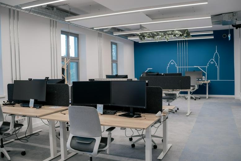 Spacious open-plan workspace at Taylor, Havellandstraße 10, Käfertal, Mannheim with adjustable desks and blue mural.