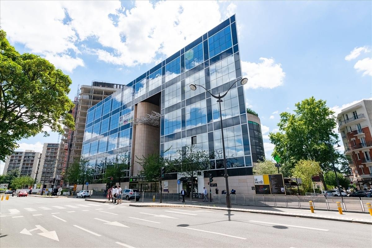 Exterior view of the modern glass-facade building at 104 Avenue Albert 1er.